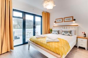 a bedroom with a large bed and a balcony at 2 Bed in Westward Ho oc-idleho in Northam
