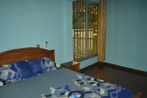 a bedroom with a bed and a window with a view at Résidence cosy proche chûtes de la Lobe in Kribi
