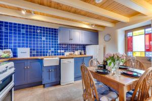 a kitchen with blue cabinets and a wooden table with chairs at 2 Bed in St Just oc-crownm in St. Just