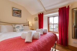 a bedroom with a large bed with red curtains at 2 Bed in St Just oc-crownm in St. Just