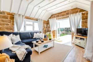 a living room with a blue couch and a stone wall at 3 Bed in Scarborough oc-sa004 in Ravenscar