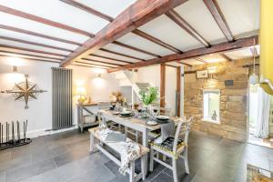 a dining room with a table and chairs and a stone wall at 3 Bed in Scarborough oc-sa004 in Ravenscar
