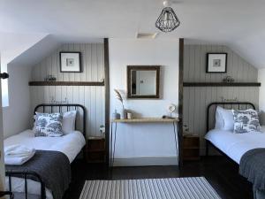 a bedroom with two beds and a mirror on the wall at 3 Bed in Scarborough oc-sa004 in Ravenscar