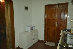 a kitchen with a microwave on top of a refrigerator at Résidence cosy proche chûtes de la Lobe in Kribi