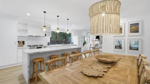 a kitchen and dining room with a table and chairs at Forries Beach Cottage in Wamberal