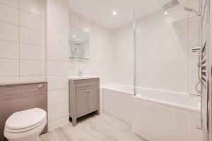 a white bathroom with a toilet and a bath tub at 3 Bed in Looe oc-l30071 in Looe +9 photos
