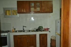 a small kitchen with a sink and a refrigerator at Résidence cosy proche chûtes de la Lobe in Kribi