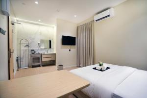 a hotel room with a white bed and a table at ALVILLA Kampung Cina in Kuala Terengganu +95 photos