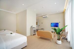 a bedroom with a bed and a desk and a chair at ALVILLA Kampung Cina in Kuala Terengganu