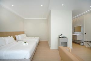 a hotel room with two beds and a couch at ALVILLA Kampung Cina in Kuala Terengganu