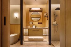 a bathroom with a sink and a toilet and a mirror at Doradora Boutique Hotel in Fusong +124 photos