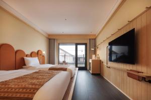 a hotel room with two beds and a flat screen tv at Doradora Boutique Hotel in Fusong