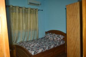 a small bed in a room with a window at Résidence cosy proche chûtes de la Lobe in Kribi +16 photos