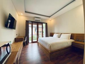 a bedroom with a large bed and a television at Indarti Living in Sukawati