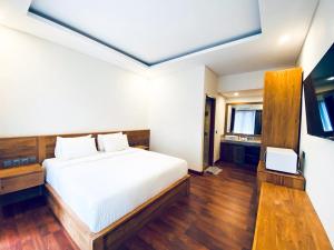 a bedroom with a white bed and a television at Indarti Living in Sukawati
