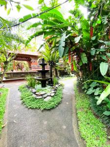 a garden with a fountain and plants and a building at Indarti Living in Sukawati