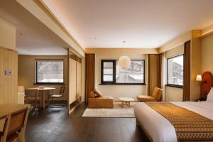 a hotel room with a bed and a dining room at Doradora Boutique Hotel in Fusong