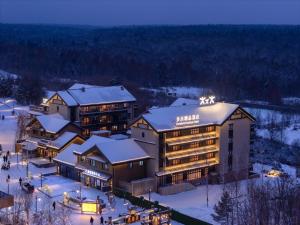 an aerial view of a hotel in the snow at night at Doradora Boutique Hotel in Fusong