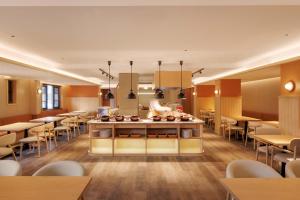 a restaurant with a chef preparing food in a cafeteria at Doradora Boutique Hotel in Fusong