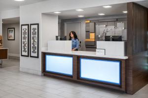 a woman standing behind a counter in a store at Holiday Inn Express San Diego - Sea World Area by IHG in San Diego +38 photos