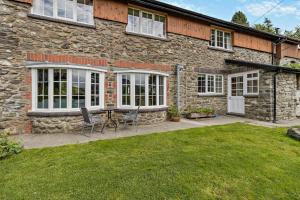 a stone house with a table and chairs in the yard at 3 Bed in Cemmaes Road oc-h29101 in Cemmaes