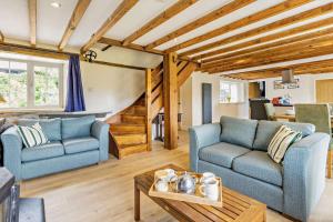 a living room with two blue couches and a table at 3 Bed in Cemmaes Road oc-h29101 in Cemmaes