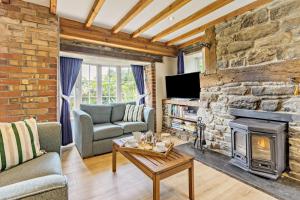 a living room with a fireplace and a stone wall at 3 Bed in Cemmaes Road oc-h29101 in Cemmaes