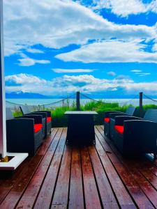 a table and chairs on a wooden deck with a view at Oceanhouse in Homer