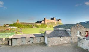 a view of a castle and a tennis court with buildings at 2 Bed in Bamburgh oc-gd0248 in Bamburgh +9 photos