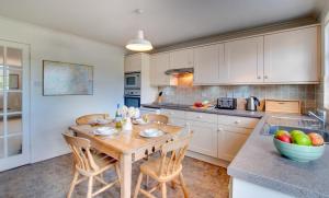 a kitchen with a wooden table and chairs in it at 2 Bed in Bamburgh oc-gd0248 in Bamburgh