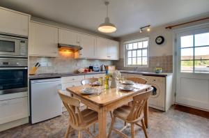 a kitchen with a wooden table and chairs in it at 2 Bed in Bamburgh oc-gd0248 in Bamburgh