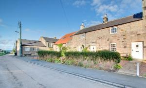 an empty street next to an old brick building at 2 Bed in Bamburgh oc-gd0248 in Bamburgh
