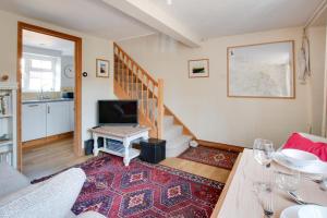 a living room with a staircase and a television at 1 Bed in Holt oc-1838 in Holt