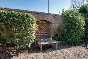 a wooden bench sitting in front of a brick wall at 1 Bed in Holt oc-1838 in Holt