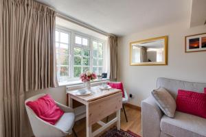 a room with a desk and a couch and a window at 1 Bed in Holt oc-1838 in Holt +3 photos