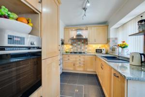 a large kitchen with wooden cabinets and appliances at 4 Bed in Buxton oc-dcjar in Tideswell +9 photos