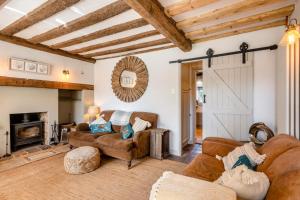 a living room with leather furniture and a barn door at 2 Bed in Wiveton oc-g29762 in Wiveton