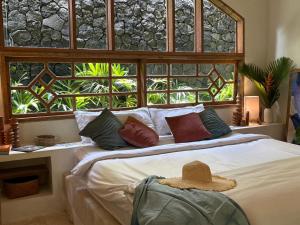 a bedroom with a bed with a hat on it at Tropical Villa Canggu Beach in Dalung