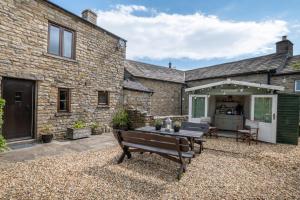 a stone house with a patio and a table at 3 Bed in Carperby oc-ds1033 in Carperby