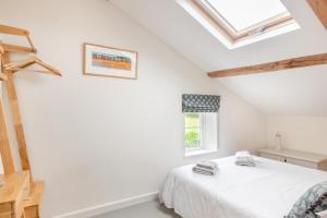 a white bedroom with a bed and a window at 2 Bed in Holt oc-2027 in Thornage