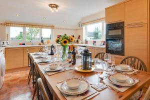 a kitchen with a long table with plates and glasses at 6 Bed in Keswick oc-ld177 in Keswick