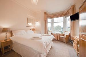 a bedroom with a large white bed and a window at 6 Bed in Keswick oc-ld177 in Keswick