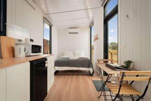 a room with a bed and a kitchen with a desk at Bellellen Park 1 by Tiny Away in Stawell