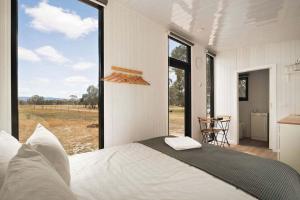 a bedroom with a bed and a large window at Bellellen Park 1 by Tiny Away in Stawell