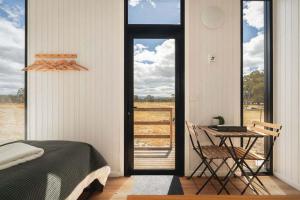 a bedroom with a bed and a table and a window at Bellellen Park 1 by Tiny Away in Stawell