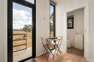 a room with a table and chairs and a window at Bellellen Park 1 by Tiny Away in Stawell +8 photos
