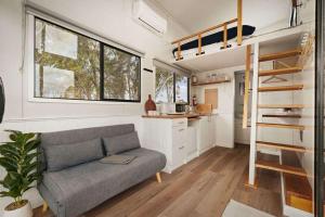 a living room with a couch in a tiny house at Bellellen Park 2 by Tiny Away in Stawell
