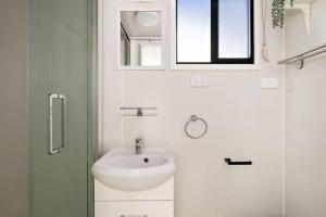 a white bathroom with a sink and a window at Bellellen Park 2 by Tiny Away in Stawell +11 photos