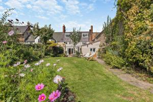 a garden with pink flowers in front of a house at 4 Bed in Ruthin oc-a29543 in Ruthin