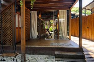 an external view of a house with a wooden porch at Vilarejo Hospedagem in Ilha do Mel
